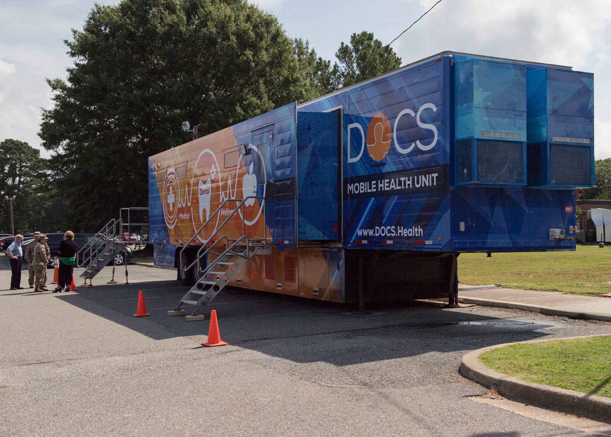 Fort Eustis personnel talk to Army and Air Force Exchange Service members during the grand opening of the Dentrust Optimized Care Solutions mobile treatment facility at Joint Base Langley-Eustis, Virginia, July 8, 2019.