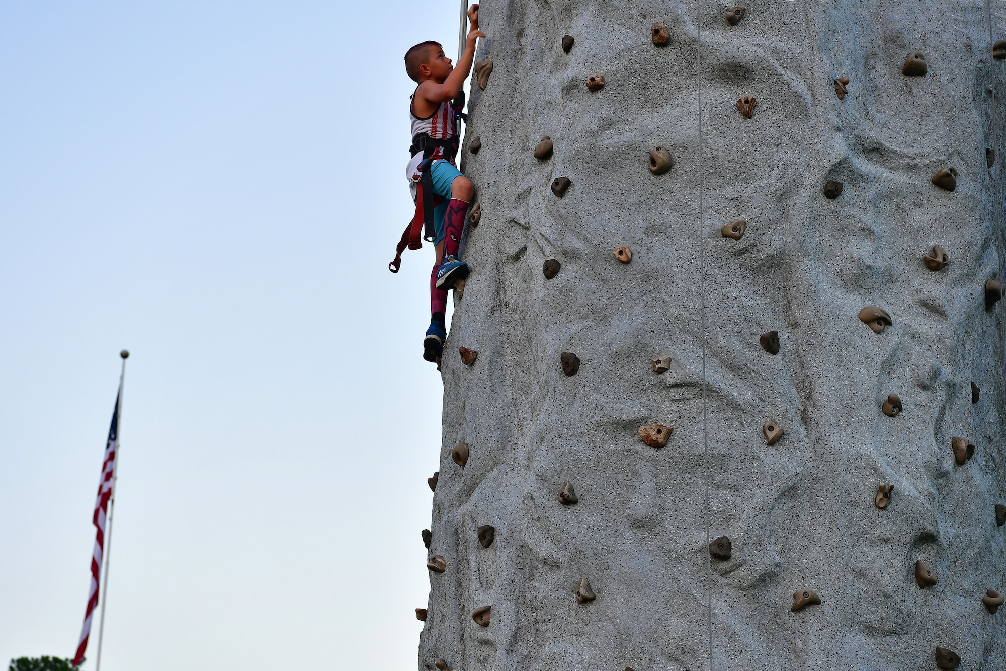 A child climbs a rock wall at the Liberty Fest.