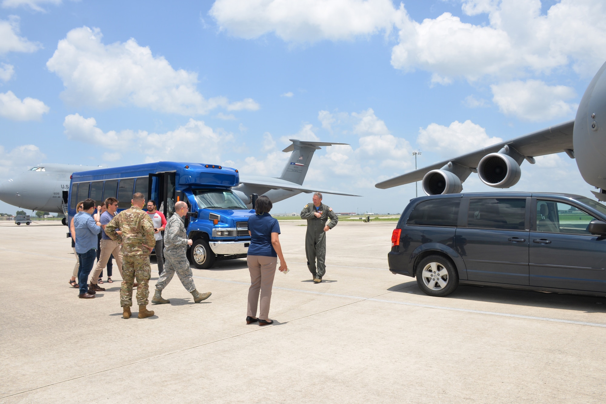 Actors and support staff from the Arts in the Armed Forces head toward a C-5M Super Galaxy, June 28, 2019, at Joint Base San Antonio-Lackland, Texas, for a tour of the massive aircraft.