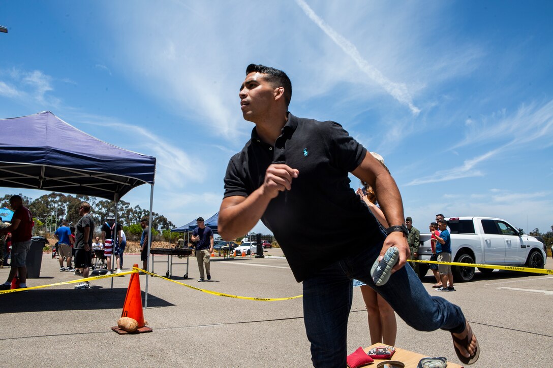 1st Lt. Spencer Buettner, an Infantry Officer with Headquarters and Headquarters Squadron (H&HS), participates in the cornhole tournament during the H&HS Barbecue Cook-off at Marine Corps Air Station Miramar, Calif., Jul. 3. The H&HS Barbecue Cook-off was held this month in order to build unit cohesion and boost morale throughout the squadron. (U.S. Marine Corps photo by LCpl. Andrew Hiatt)