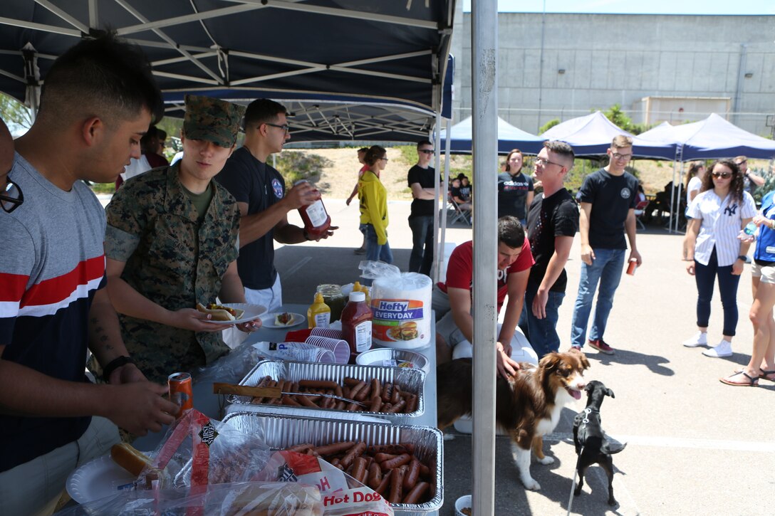 Marines with Headquarters and Headquarters Squadron (H&HS) get to know each other better while standing in line for lunch during the H&HS Barbecue Cook-off at Marine Corps Air Station Miramar, Calif., Jul. 3. The H&HS Barbecue Cook-off was held this month in order to build unit cohesion and boost morale throughout the squadron. (U.S. Marine Corps photo by LCpl. Andrew Hiatt)