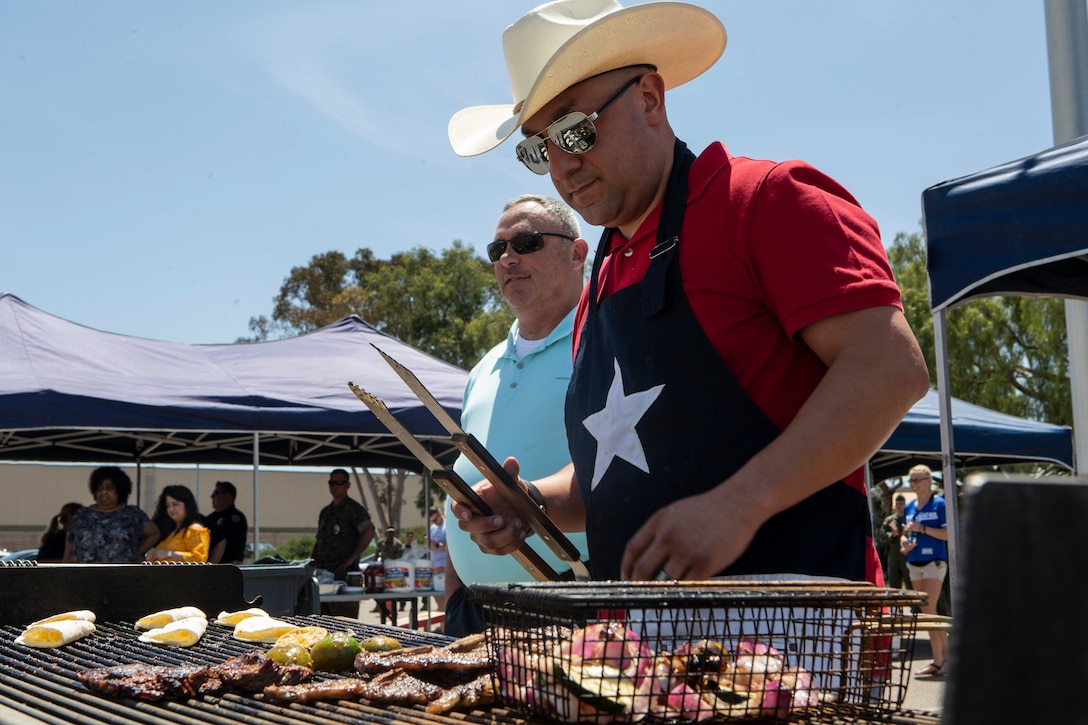 GySgt. Mario Cardenas, with Provost Marshal's Office (PMO), Headquarters and Headquarters Squadron (H&HS), prepares lunch for the H&HS Barbecue Cook-off at Marine Corps Air Station Miramar, Calif., Jul. 3. The H&HS Barbecue Cook-off was held this month in order to build unit cohesion and boost morale throughout the squadron. (U.S. Marine Corps photo by LCpl. Andrew Hiatt)