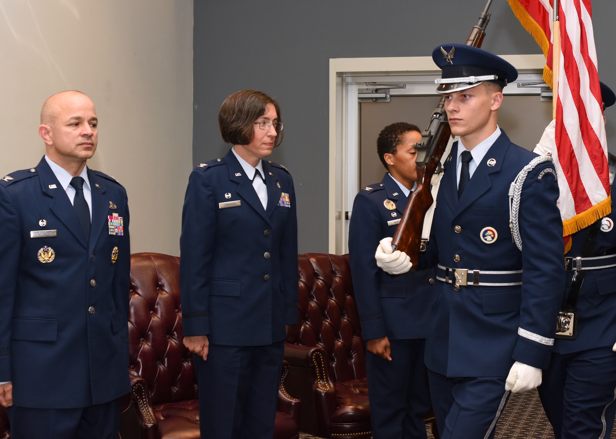 U.S. Air Force Col. Andres Nazario, 17th Training Wing commander, Col. Janet Urbanski, 17th Medical Group outgoing commander, and Col. Lauren Byrd, 17th MDG incoming commander show respect by standing at attention for the posting of colors at the 17th MDG Change of Command Ceremony at the event center on Goodfellow Air Force Base, Texas, July 8, 2019. The posting of colors is a formality done at the beginning of military ceremonies and public events by the color guard to properly position the flags. (U.S. Air Force photo by Airman 1st Class Abbey Rieves/Released)