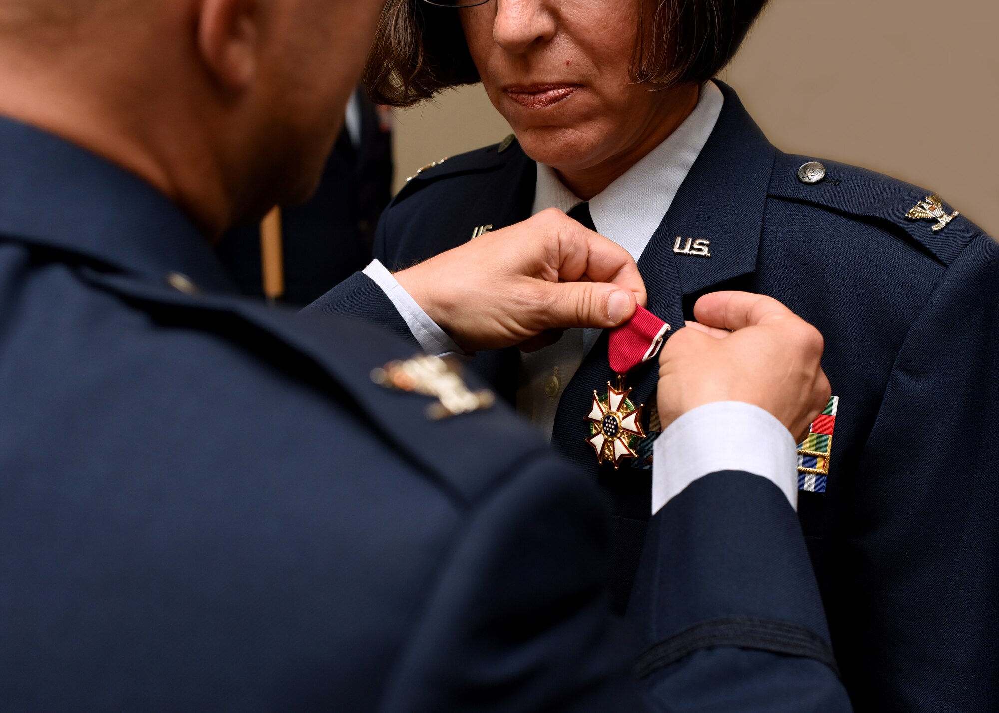 U.S. Air Force Col. Andres Nazario, 17th Training Wing commander, pins Col. Janet Urbanski, 17th Medical Group outgoing commander, with the Legion of Merit medal for her accomplishments as commander during the 17th MDG Change of Command Ceremony held at the event center on Goodfellow Air Force Base, Texas, July 8, 2019. Urbanski was awarded the accolade for praiseworthy service over the past two years at Goodfellow. (U.S. Air Force photo by Airman 1st Class Abbey Rieves/Released)