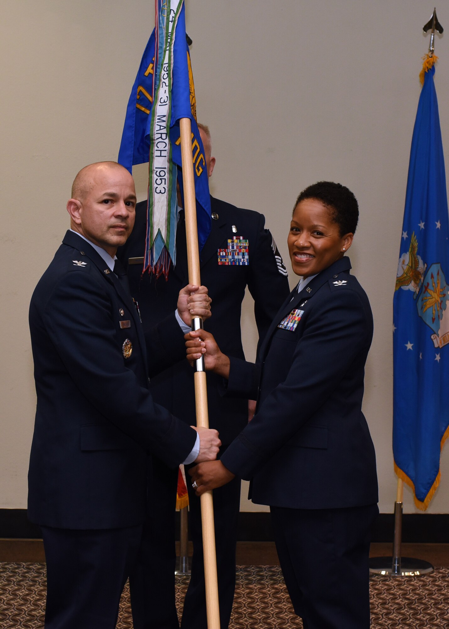 U.S. Air Force Col. Andres Nazario, 17th Training Wing commander, formally hands command to Col. Lauren Byrd, 17th Medical Group incoming commander, during the 17th MDG Change of Command Ceremony held at the event center on Goodfellow Air Force Base, Texas, July 8, 2019. Byrd was the 11th Medical Group Administrator at Joint Base Andrews, Maryland, prior to her current assignment at Goodfellow. (U.S. Air Force photo by Airman 1st Class Abbey Rieves/Released)