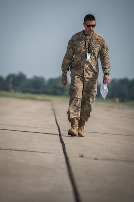 Master Sgt. Sandro Cardona, flightline expediter, 932nd Airlift Wing Maintenance Squadron, scans the flightline for debris during the weekly foreign object debris (FOD) walk, July 9, 2019, Scott Air force Base, Illinois. (U.S. Air Force photo by Christopher Parr)