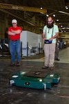 Production Machinery Mechanic Ethan Holland operates the TK-EVO Heavy Lifting Device using a remote-controlled device.