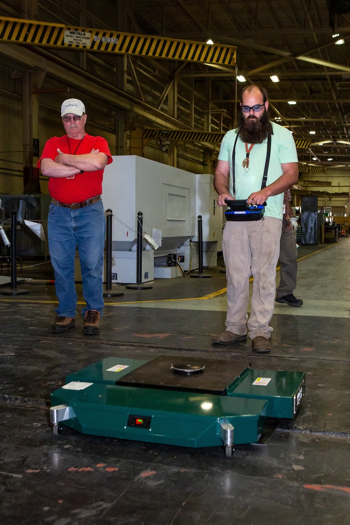 Production Machinery Mechanic Ethan Holland operates the TK-EVO Heavy Lifting Device using a remote-controlled device.