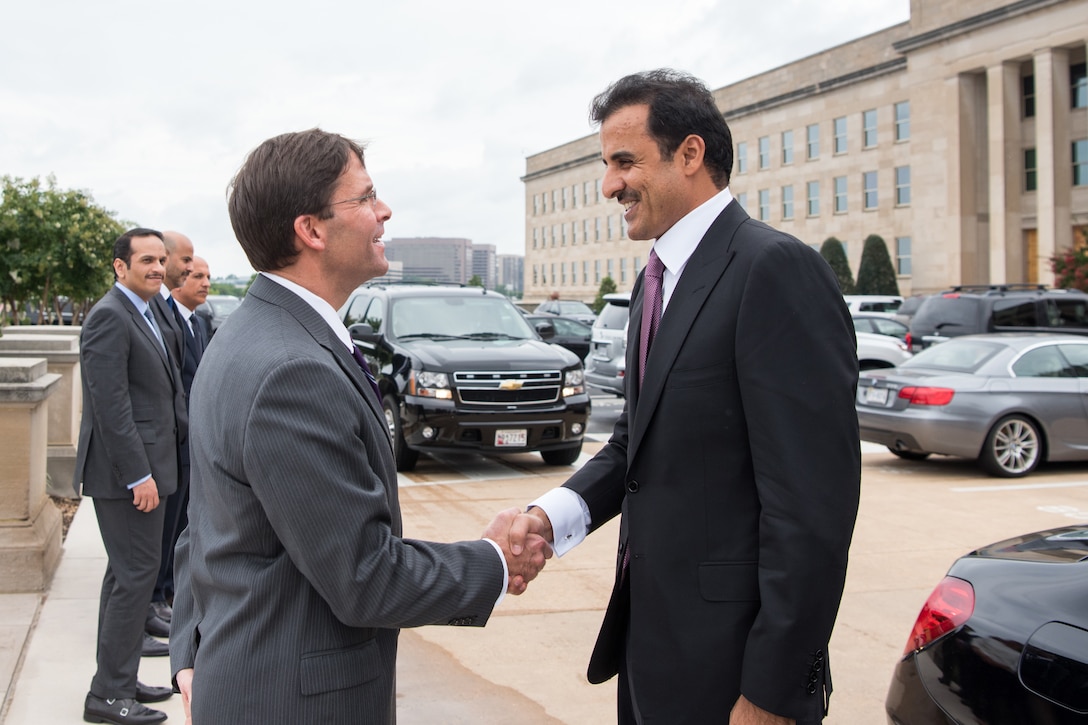 Two men shake hands.