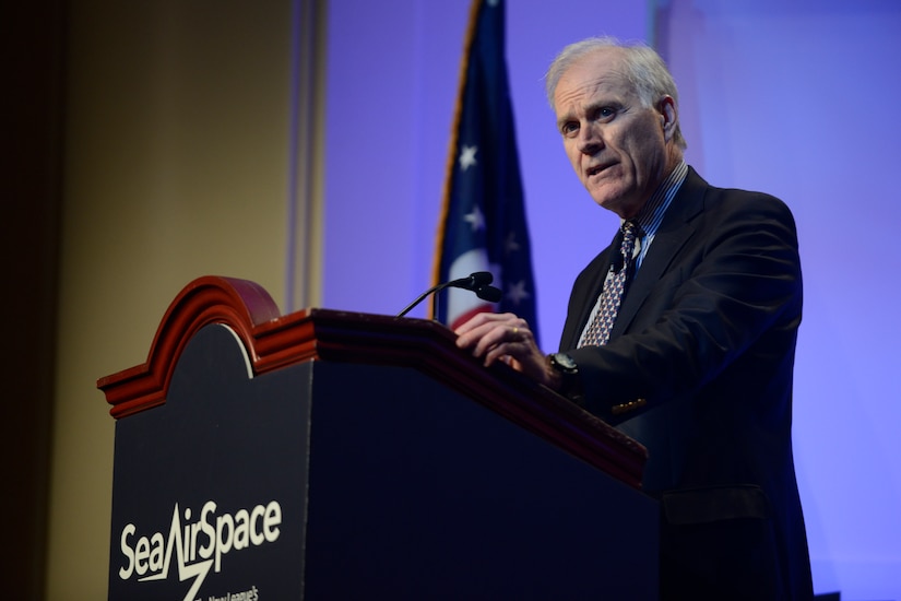 A man speaks at a podium.