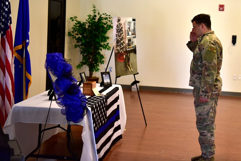 Staff Sgt. Zachary McDaniel, 11th Security Support Squadron military working dog handler, salutes a memorial made for canine, Tommy, during a memorial service at the Community Commons on Joint Base Andrews, Md., July 3, 2019. McDaniel and Tommy served together for two years and went on one deployment. (U.S. Air Force photo by Airman 1st Class Noah Sudolcan)