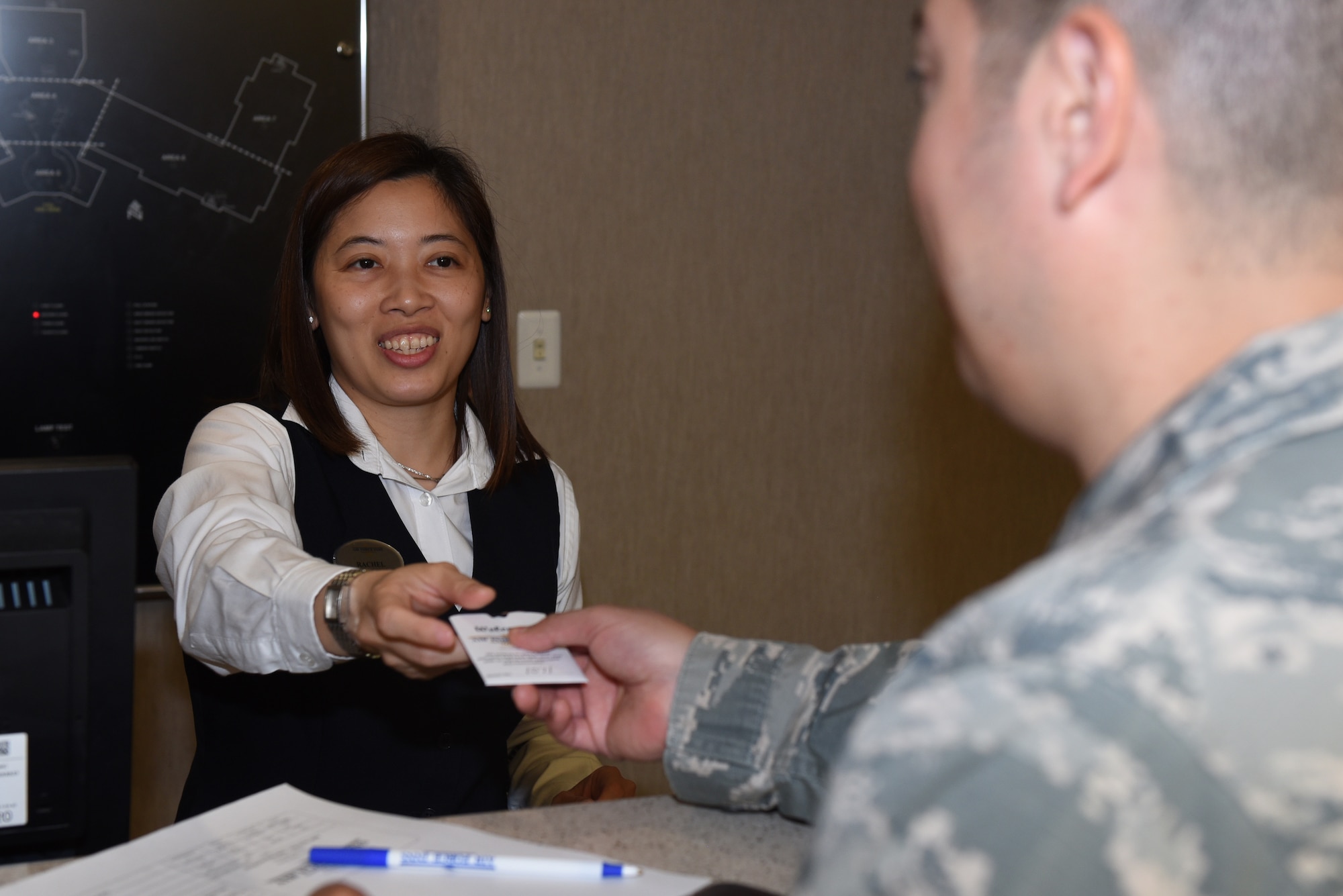 Rachel Natalya, Westwind Inn receptionist, hands U.S. Air Force Staff Sgt. Jesus Beltran, Westwind Inn guest, a room key July 8, 2019, at Travis Air Force Base, California. Westwind Inn is one of the finalists for the Air Force’s 2019 Innkeeper Award after being named the best in Air Mobility Command. The Innkeeper Award is an annual honor recognizing excellence in the service’s lodging operations. (U.S. Air Force photo by Airman 1st Class Cameron Otte)