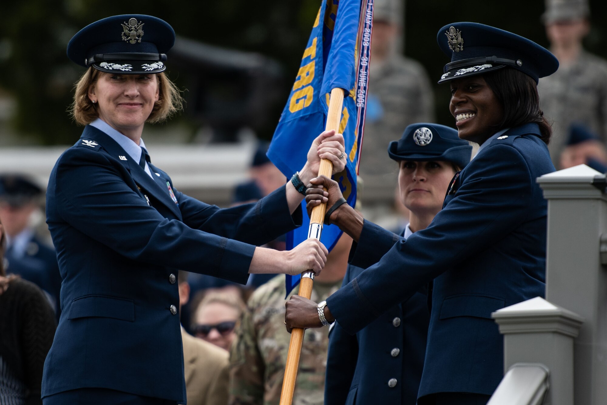 U.S. Air Force Col. Stephanie Kelley, 517th Training Group commander, passes the guidon to Lt. Col. Nicci Rucker, 311th Training Squadron incoming commander, during the change of command ceremony on Soldier Field at the Presidio of Monterey, California, July 8, 2019. The change of command ceremony is a military tradition which illustrates the formal transfer of authority by passing the guidon from the departing commander to the incoming commander via the overseeing officer. (Courtesy Photo)