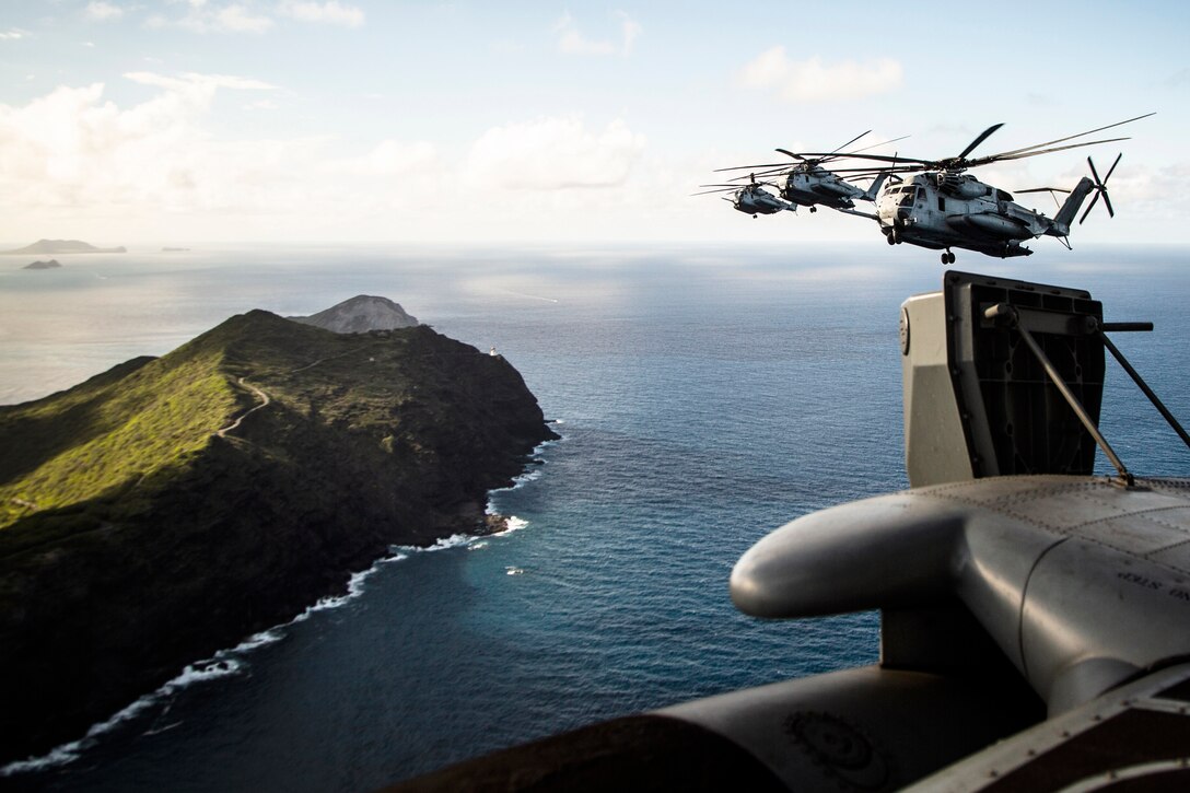 Helicopters fly over Oahu.