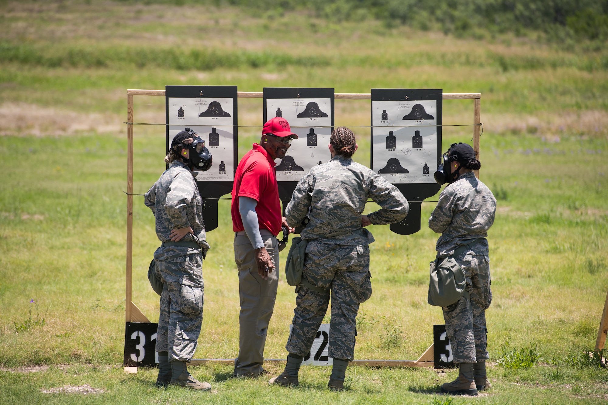 Mr. Nate Cade, 37th Training Support Squadron combat arms instructor, evaluates targets with BMT trainees during a weapons familiarization course, July 8, 2019, at Joint Base San Antonio-Medina Annex. BMT trainees were the first to experience M-4 Carbine Weapons Familiarization Course at the new facility, which closed in November 2018, due to improper rainwater drainage. The firing range allows instructors to train 244 BMT trainees daily, four days a week, qualifying more than 40,000 BMT trainees in the M-4 carbine annually. (U.S. Air Force photo by Sarayuth Pinthong)