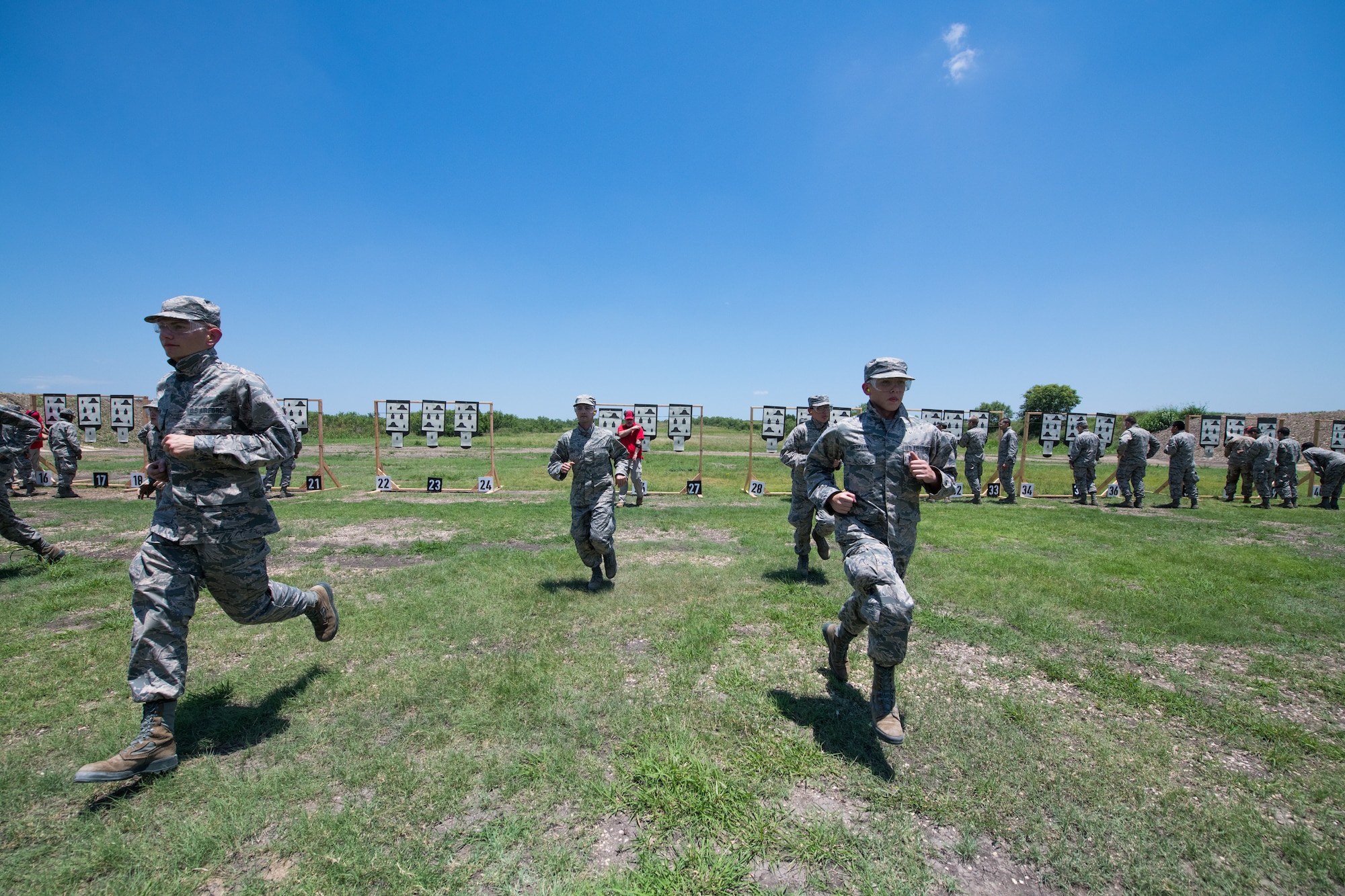 U.S. Air Force BMTs run back to their firing position after seeing their targets during a weapons familiarization course, June 8, 2019, at Joint Base San Antonio-Medina Annex. BMT trainees were the first to experience M-4 Carbine Weapons Familiarization Course at the new facility, which closed in November 2018, due to improper rainwater drainage. The firing range allows instructors to train 244 BMT trainees daily, four days a week, qualifying more than 40,000 BMT trainees in the M-4 carbine annually. (U.S. Air Force photo by Sarayuth Pinthong)