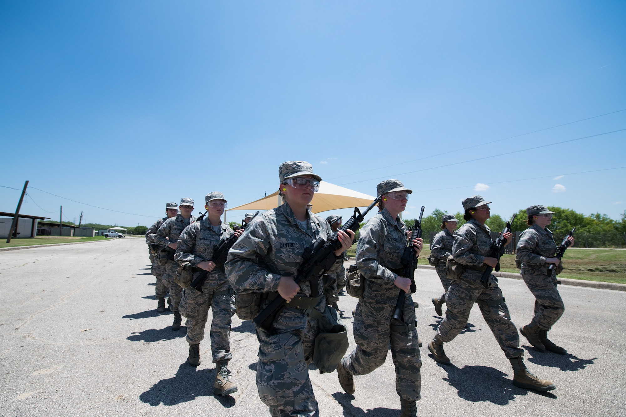 U.S. Air Force basic training trainees march back from the firing range after a weapons familiarization course, June 8, 2019, at Joint Base San Antonio-Medina Annex. BMT trainees were the first to experience M-4 Carbine Weapons Familiarization Course at the new facility, which closed in November 2018, due to improper rainwater drainage. The firing range allows instructors to train 244 BMT trainees daily, four days a week, qualifying more than 40,000 BMT trainees in the M-4 carbine annually. (U.S. Air Force photo by Sarayuth Pinthong)
