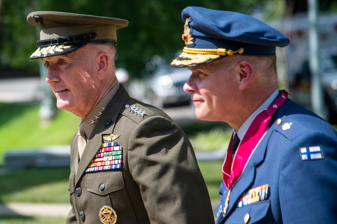 Two military commanders walk together during a ceremony.