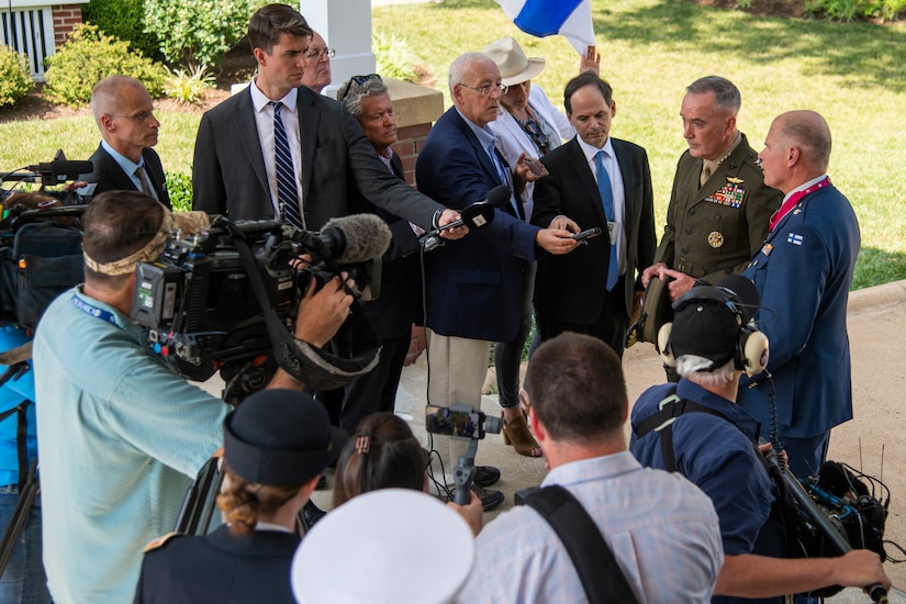 Two military officers speak to reporters.