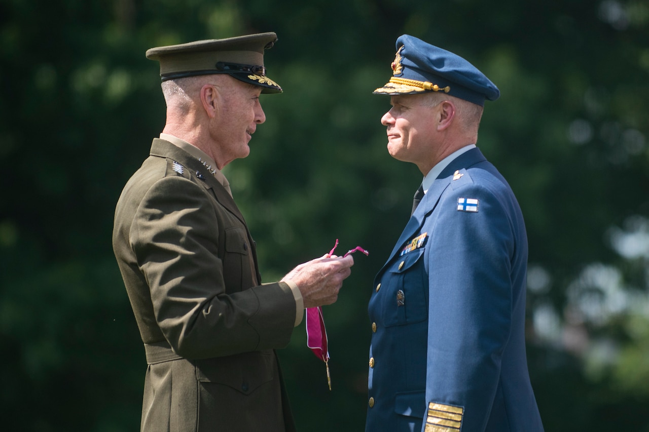 A U.S. military officer presents a medal to a Finnish officer.