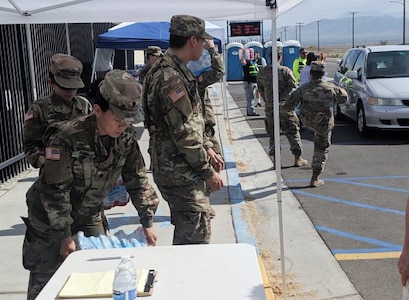 Members of the California National Guard's 143rd Military Police Battalion distribute food and water to residents of Trona, Calif., July 7, 2019 following a 7.1 magnitude earthquake Friday night that burst water lines and closed stores.