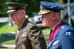 Two military commanders walk together during a ceremony.