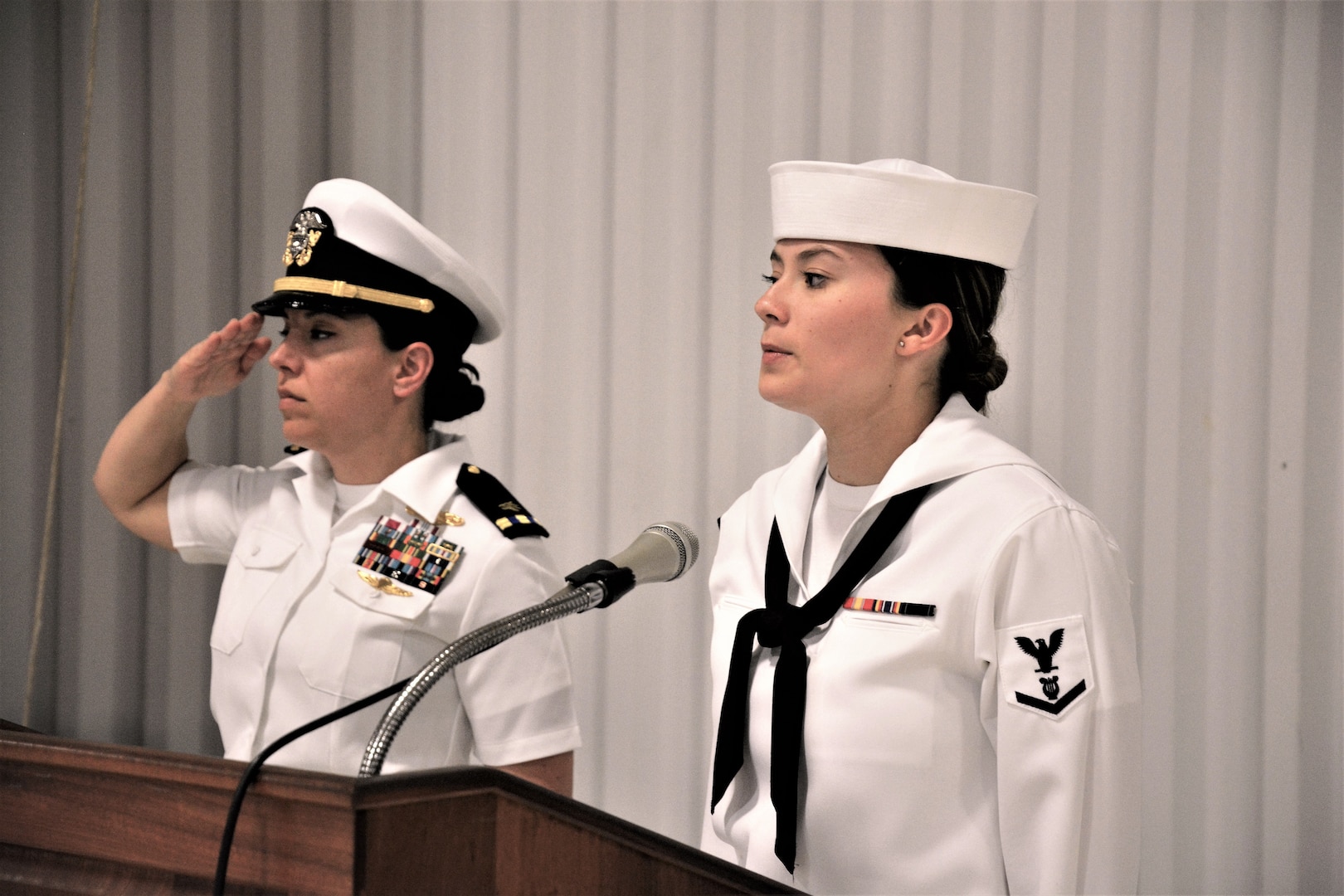 IMAGE: (Left to right) Chief Warrant Officer Josephine Leon, master of ceremony, renders a salute prior to Musician 3rd Class Amanda Huddleston, Fleet Forces Band, singing the national anthem. More than 200 Sailors and guests attended a traditional change of command ceremony at Naval Air Station (NAS) Oceana’s Center for Naval Aviation Technical Training Unit’s ceremonial hangar aboard NAS Oceana June 27 where Cmdr. Andrew Hoffman was relieved of command by Cmdr. Joseph Oravec. Oravec became the 28th commanding officer, Naval Surface Warfare Center Dahlgren Division, Dam Neck Activity.