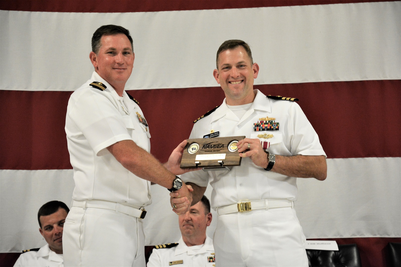 IMAGE: (Left to right) Cmdr. Casey Plew, Commanding Officer, Naval Surface Warfare Center Dahlgren Division (NSWCDD), presents Cmdr. Andrew Hoffman with a farewell plaque for his three plus years as NSWCDD Dam Neck Activity’s commanding officer. More than 200 Sailors and guests attended a traditional Change of Command ceremony at Naval Air Station (NAS) Oceana’s Center for Naval Aviation Technical Training Unit’s ceremonial hangar aboard NAS Oceana June 27 where Hoffman was relieved of command by Cmdr. Joseph Oravec. Oravec became the command’s 28th commanding officer.
