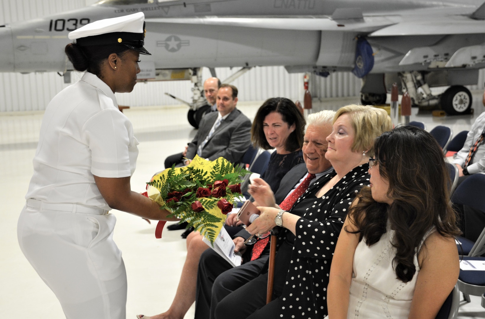 IMAGE: (Left) Chief Logistics Specialist Kisha Vilabrera presents flowers to Cmdr. Andrew Hoffman’s mother honoring her role on the home front during a traditional Change of Command ceremony at Naval Air Station (NAS) Oceana’s Center for Naval Aviation Technical Training Unit’s ceremonial hangar aboard NAS Oceana June 27. Hoffman was relieved by Cmdr. Joseph Oravec as Naval Surface Warfare Center Dahlgren Division, Dam Neck Activity’s commanding officer. Oravec becomes the 28th commanding officer for the Virginia Beach, Virginia command.