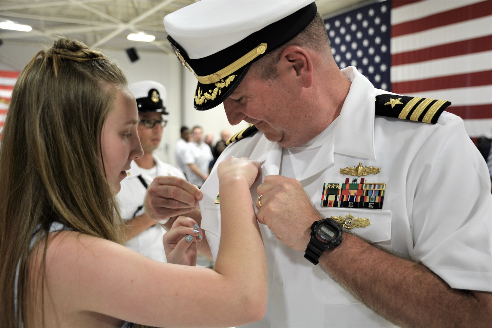 IMAGE: (Left to right) Cmdr. Joseph Oravec’s daughter pins the Commanding Officer Ashore pin to her father’s shirt following Naval Surface Warfare Center Dahlgren Division, Dam Neck Activity’s change of command. More than 200 Sailors and guests attended a traditional ceremony at Naval Air Station (NAS) Oceana’s Center for Naval Aviation Technical Training Unit’s ceremonial hangar aboard NAS Oceana June 27 where Cmdr. Andrew Hoffman was relieved of command by Oravec. Oravec became the command’s 28th commanding officer.