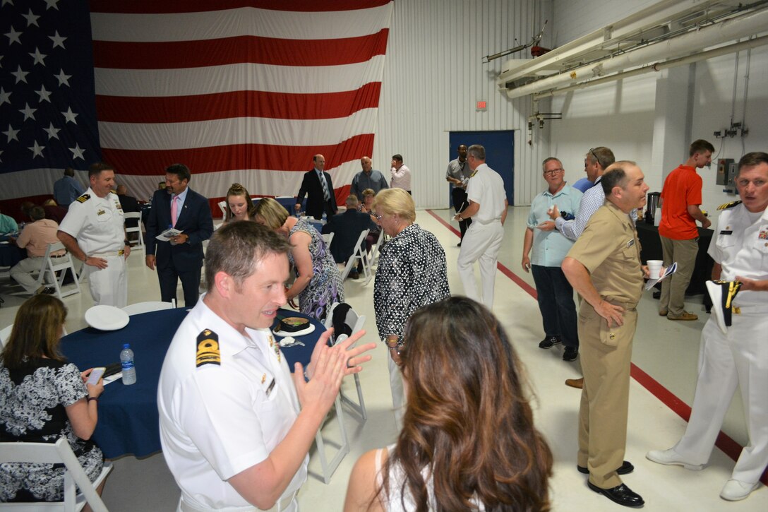 IMAGE: Guests enjoy cake, refreshments and conversations following Naval Surface Warfare Center Dahlgren Division, Dam Neck Activity’s Change of Command ceremony June 27. More than 200 Sailors and guests attended a traditional ceremony at CNATTU’s ceremonial hangar aboard NAS Oceana where Cmdr. Andrew Hoffman was relieved of command by Cmdr. Joseph Oravec, who became the command’s 28th commanding officer.