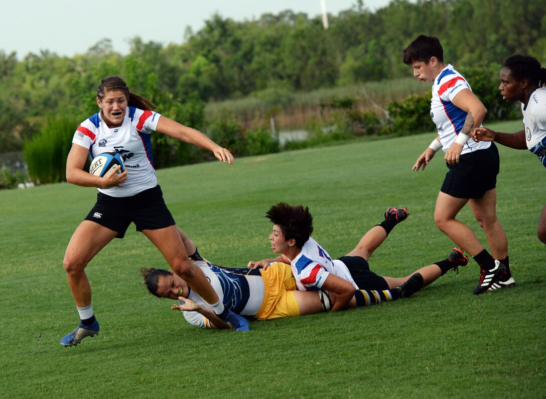 WILMINGTON, N.C. (June 6, 2019) -- Marine Capt. Kate Herren carries the ball down the pitch in the face of intense Navy defense during the Marine Corps-Navy rugby match on day two of the inaugural Armed Forces Women's Rugby Championship held in Wilmington, N.C. July 5-7, 2019. This historic event features the best female rugby players from the Army, Marine Corps, Navy, Air Force, and Coast Guard, who will compete for the title of the first ever Women's Rugby Champs (U.S. Dept. of Defense photo by Chief Mass Communication Specialist Patrick Gordon/RELEASED)