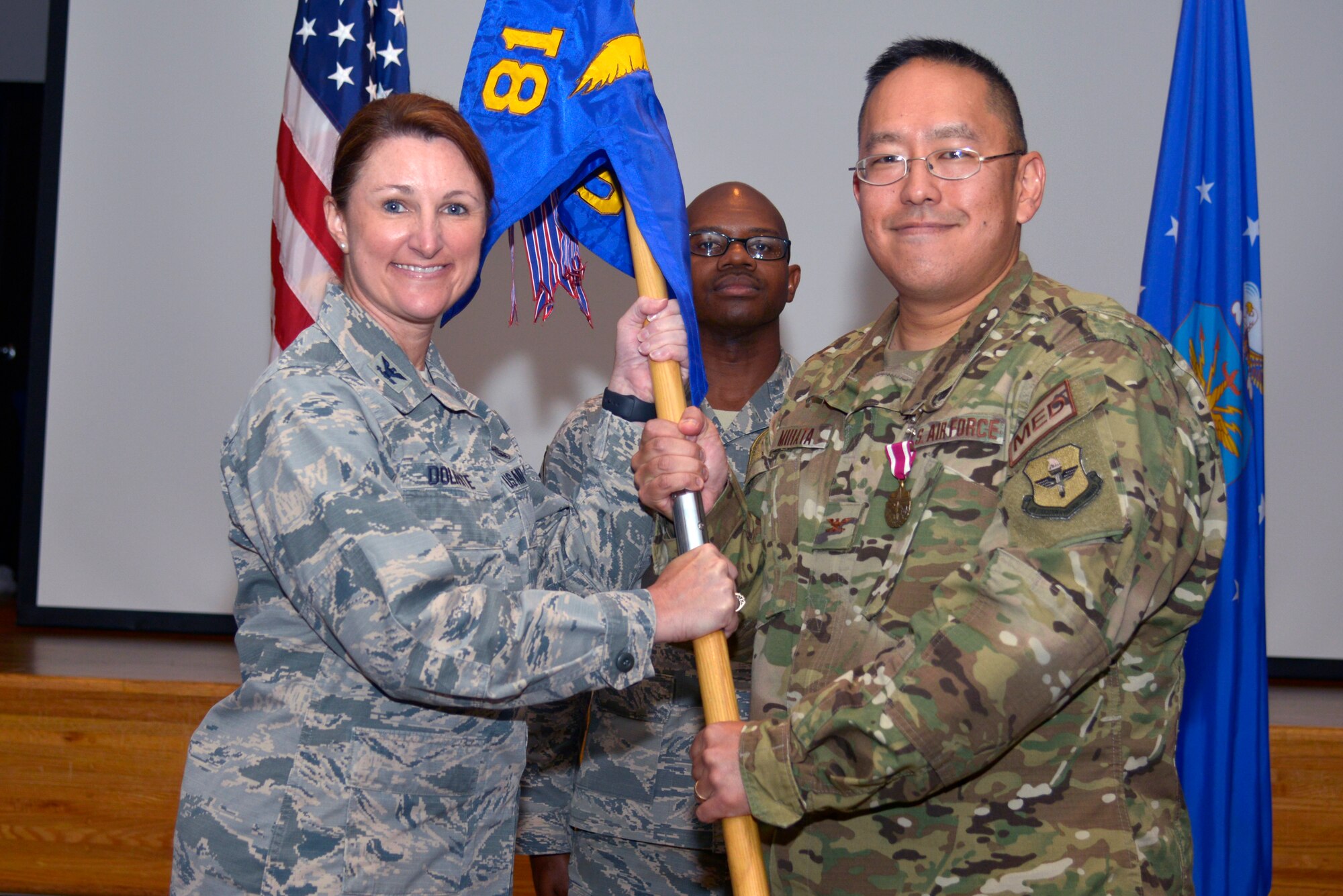 U.S. Air Force Col. Beatrice Dolihite, 81st Medical Group commander, receives the 81st Surgical Operations Squadron guidon from Col. Ryan Mihata, outgoing 81st MSGS commander, during the 81st MSGS change of command ceremony inside the Don Wylie Auditorium at Keesler Air Force Base, Mississippi, July 9, 2019. The passing of the guidon is a ceremonial symbol of exchanging command from one commander to another. Mihata passed on command of the 81st MSGS to Lt. Col. Norris Jackson. (U.S. Air Force photo by Airman Seth Haddix)