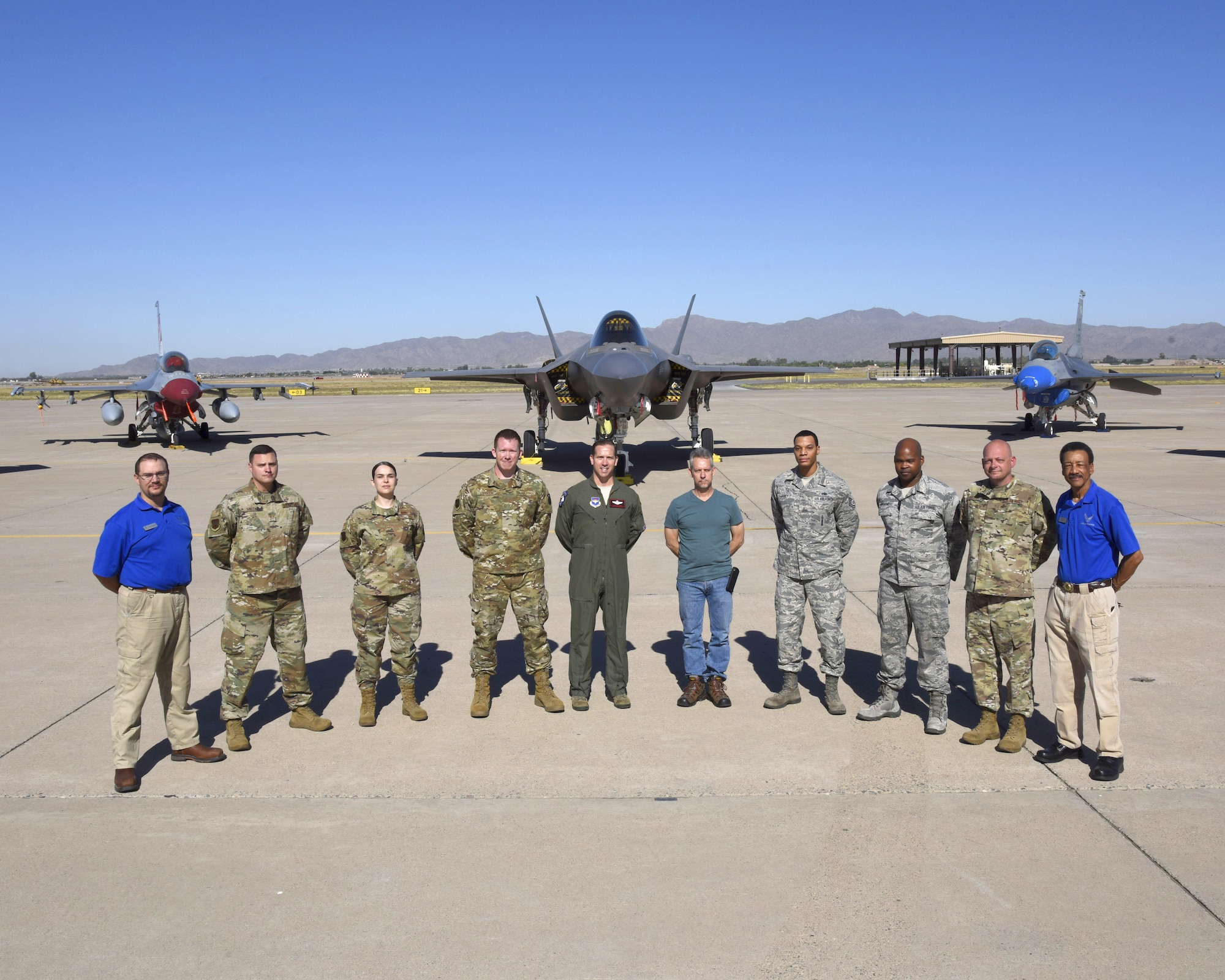 Members of the 56th Fighter Wing Safety Office stand for a group photo on the runway with a F-35A Lightning II and a F-16 Fighting Falcon, May 30, 2019, at Luke Air Force Base, Ariz. The Safety Office is comprised of three different sections; weapons, flight and occupational, these sections work together to ensure the safety of the Airmen and the base. (U.S. Air Force photo by Airman Brooke Moeder)