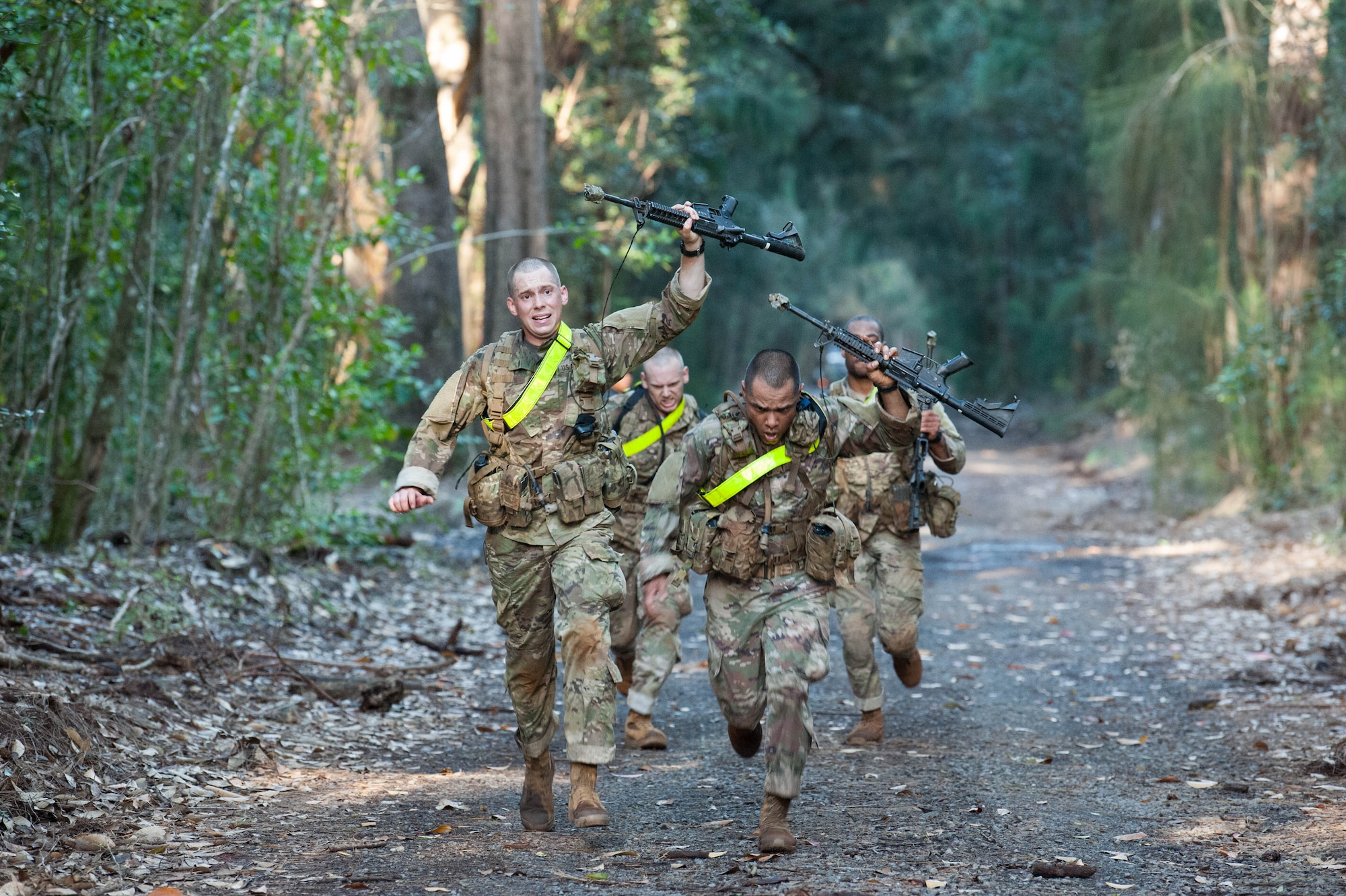 Airmen speed past the finish line after running two miles for a Ranger Assessment Course through the hills of a training camp near Schofield Barracks, Oahu, Hawaii, May 20, 2019. Throughout the 19-day course, Airmen were tested on their ability to perform land navigation, ambush, react to contact and squad attacks. Along with those assessments, the students went on runs and marches of different distances – all leading up to a 12-mile ruck march two days before graduation. (U.S. Air Force photo by Staff Sgt. Hailey Haux)