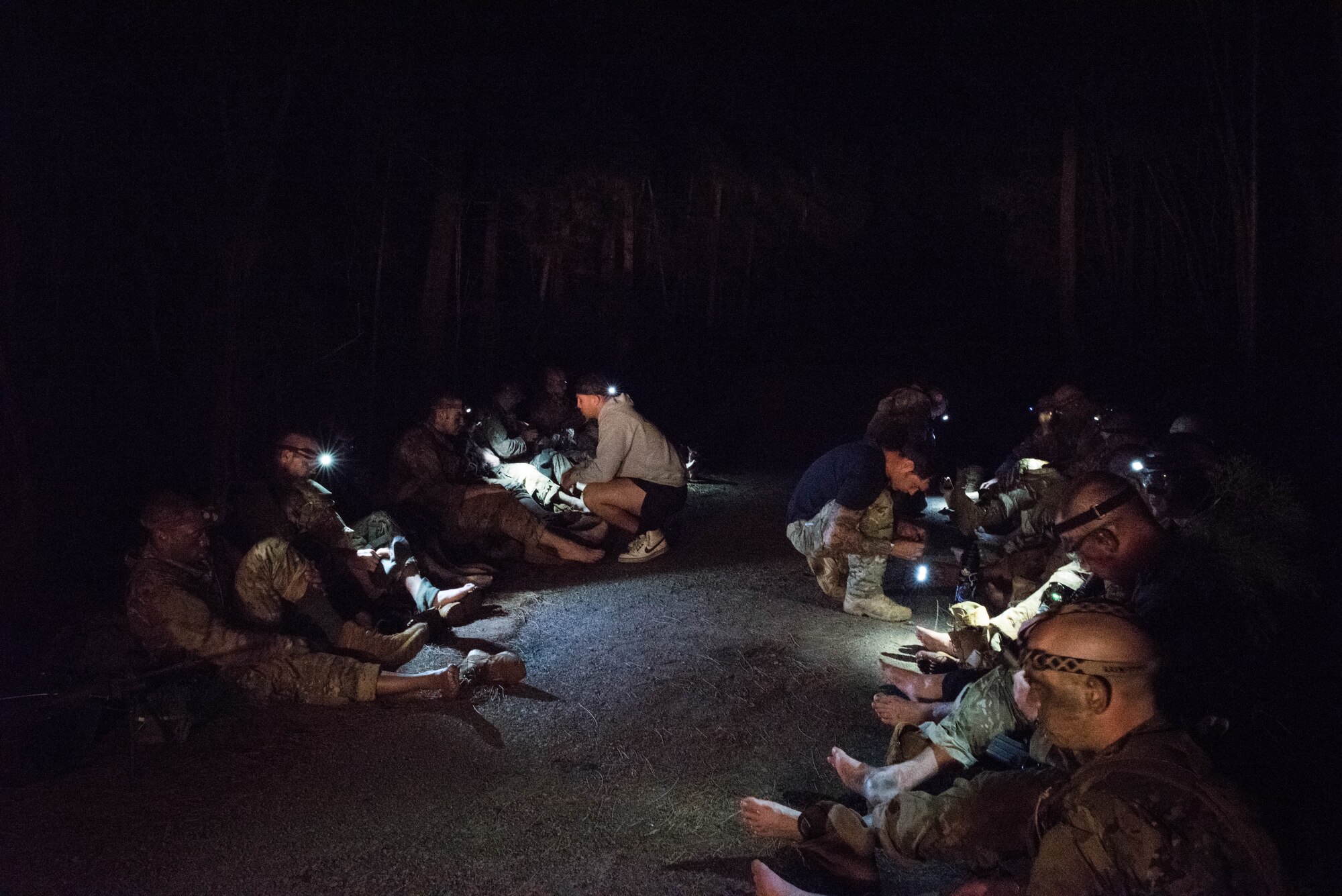 Ranger Assessment Course students have their feet looked at by RAC cadre and medical personnel after a day in the field near Schofield Barracks, Oahu, Hawaii, May 23, 2019. The Airmen who pass the Ranger Assessment Course gain more than a ticket into Ranger School and knowledge on Army tactics – they learn to lead. Throughout the course, Airmen were tested on their ability to perform land navigation, ambush, react to contact and squad attacks. Along with those assessments, the students went on runs and marches of different distances – all leading up to a 12-mile ruck march two days before graduation. (U.S. Air Force photo by Staff Sgt. Hailey Haux)