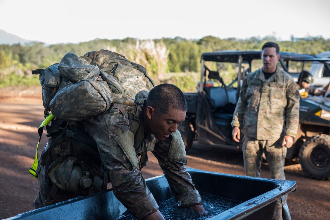 1st Lt. Jeffrey Poekhan, Ranger Assessment Course student, places his arms in ice water during a 12-mile ruck march near Schofield Barracks, Oahu, Hawaii, May 29, 2019. The purpose of the 19-day course is to prepare, assess and evaluate Air Force candidates for Army Ranger School. Of the 23 Airmen who began the Ranger Assessment Course, three dropped for personal motivational reasons and one dropped for medical reasons, leaving 19 standing at the end. Out of the 19, 11 Airmen met all the standards needed for a recommendation to go forward to Ranger School. (U.S. Air Force photo by Staff Sgt. Hailey Haux)