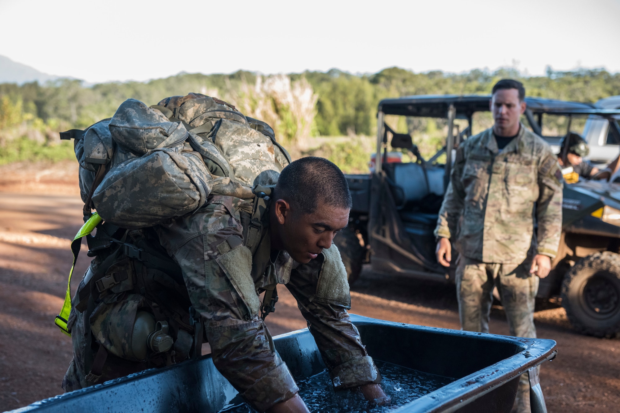 1st Lt. Jeffrey Poekhan, Ranger Assessment Course student, places his arms in ice water during a 12-mile ruck march near Schofield Barracks, Oahu, Hawaii, May 29, 2019. The purpose of the 19-day course is to prepare, assess and evaluate Air Force candidates for Army Ranger School. Of the 23 Airmen who began the Ranger Assessment Course, three dropped for personal motivational reasons and one dropped for medical reasons, leaving 19 standing at the end. Out of the 19, 11 Airmen met all the standards needed for a recommendation to go forward to Ranger School. (U.S. Air Force photo by Staff Sgt. Hailey Haux)