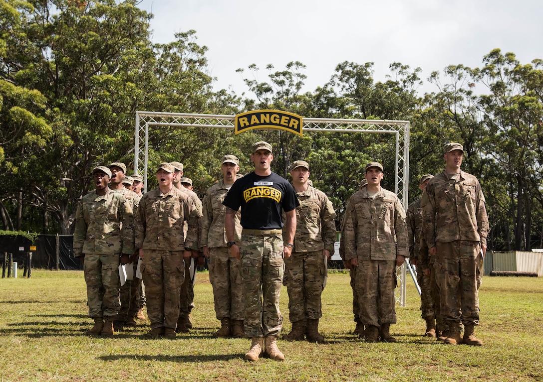Tech. Sgt. Keegan Donnelly, Ranger Assessment Course lead cadre, and RAC students recite the Ranger Creed during the graduation ceremony near Schofield Barracks, Oahu, Hawaii, May 31, 2019. The purpose of the three-week course is to prepare, assess and evaluate Air Force candidates for Army Ranger School. Of the 23 Airmen who began the Ranger Assessment Course, three dropped for personal motivational reasons and one dropped for medical reasons, leaving 19 standing at the end. Out of the 19, 11 Airmen met all the standards needed for a recommendation to go forward to Ranger School. (U.S. Air Force photo by Staff Sgt. Hailey Haux)