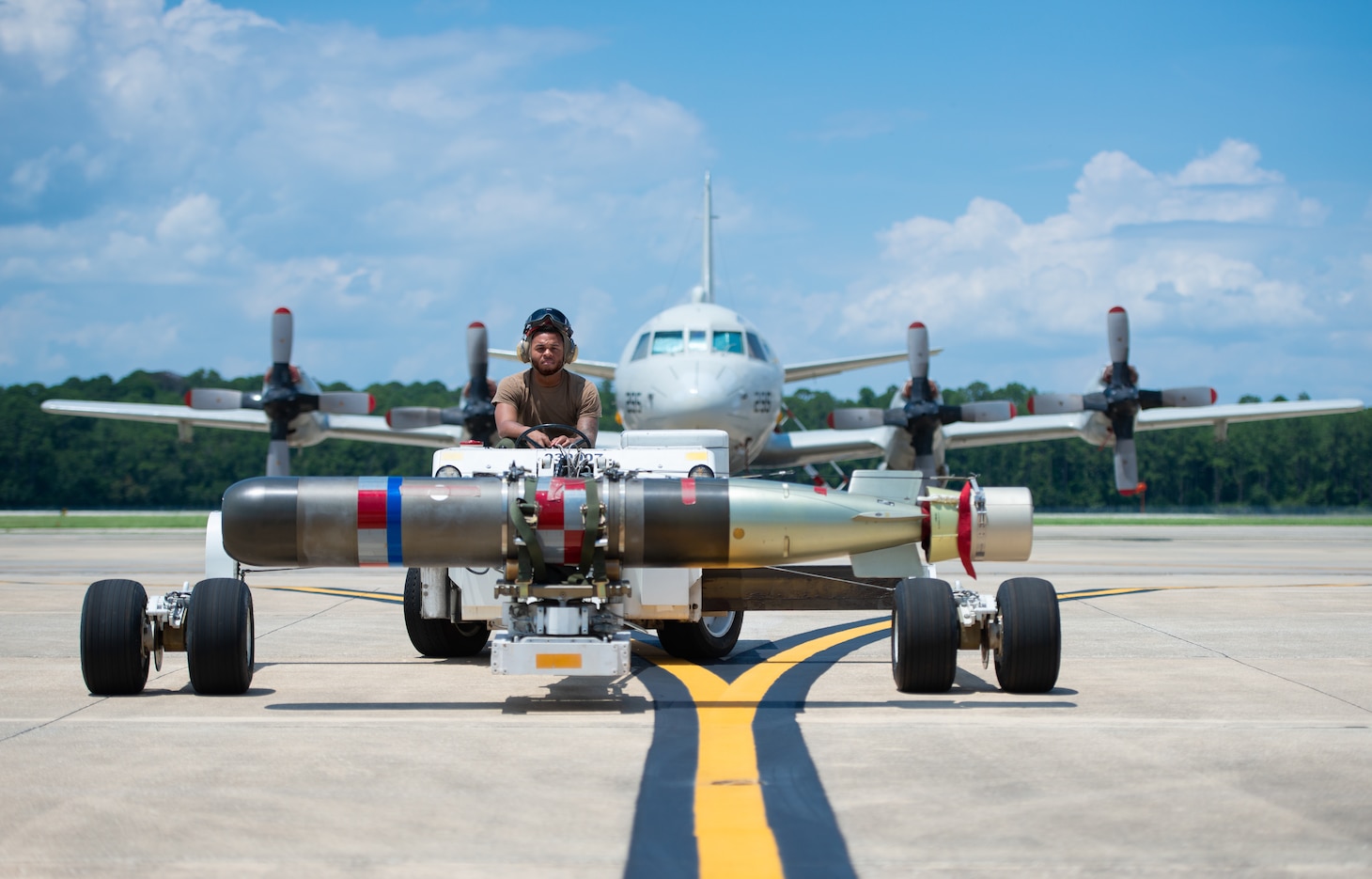 A Sailor driving a vehicle away form an aircraft