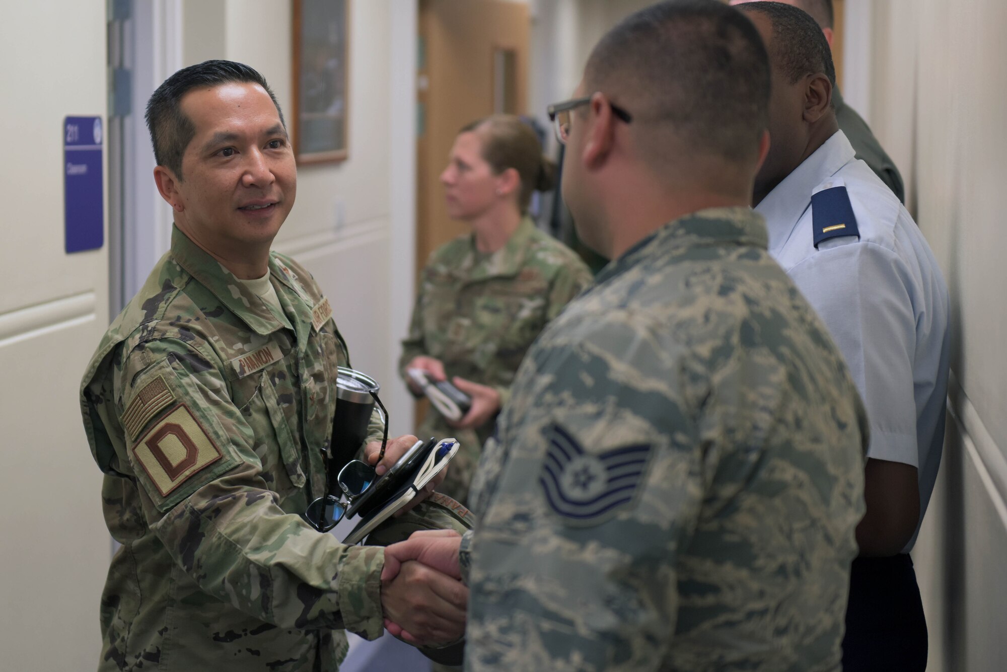 U.S. Air Force Col. Troy Pananon, 100th Air Refueling Wing commander, shakes hands with a 100th ARW Airman at RAF Mildenhall, England, July 9, 2019. Pananon began his military career in the United States Marine Corps, after leaving the USMC he completed his education and earned his commission in the Air Force. (U.S. Air Force photo by Senior Airman Benjamin Cooper)