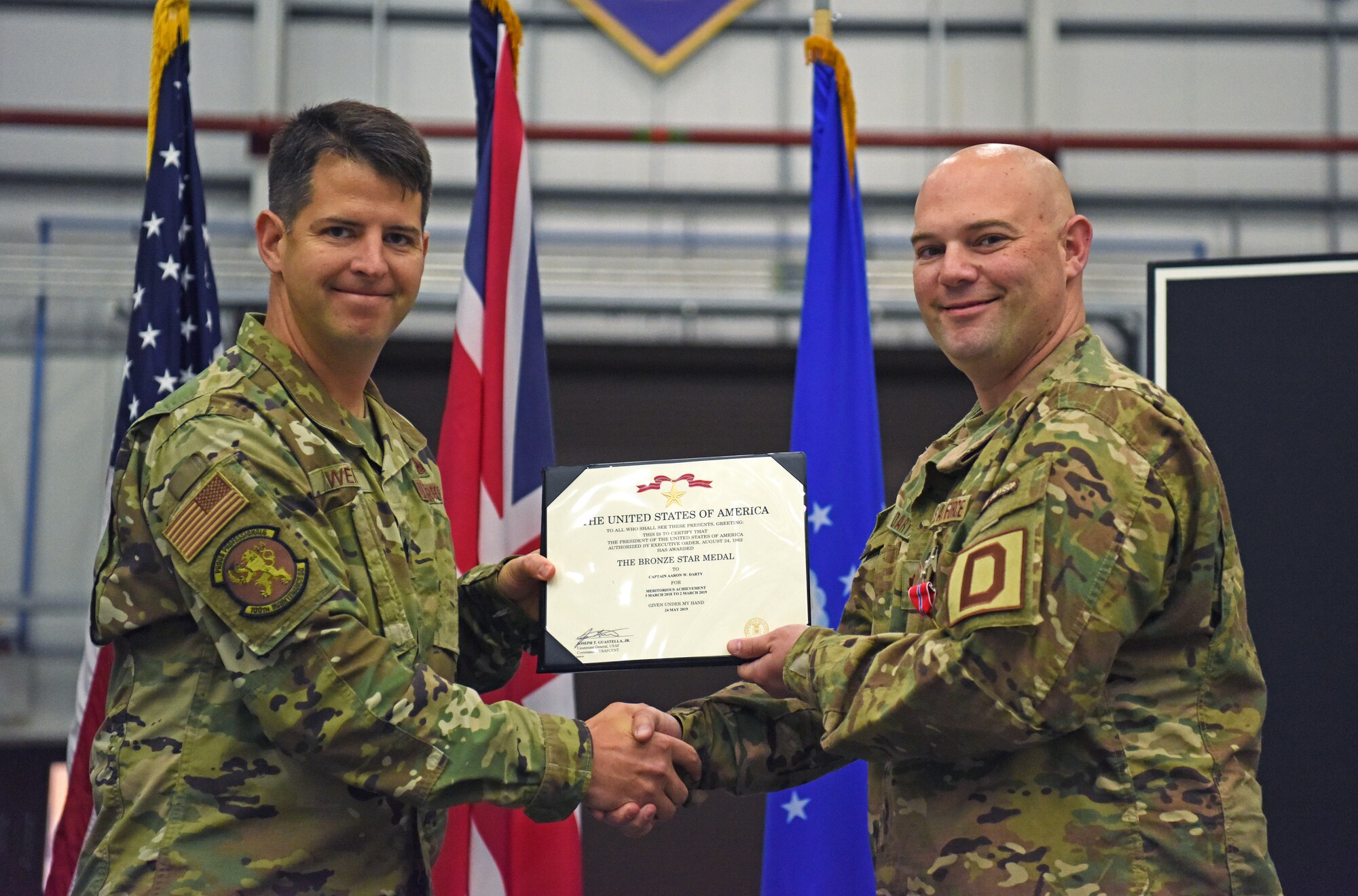 U.S. Air Force Lt. Col. Paul Weme, 100th Maintenance Group commander, presents Maj. Aaron Darty, 100th Maintenance Squadron operations officer, with a Bronze Star Medal during a ceremony held at RAF Mildenhall, England, July 1, 2019. Darty was recently awarded the Bronze Star Medal for meritorious achievement as operations officer and maintenance advisor in support of Operation Freedom Sentinel while deployed to Kandahar Airfield, Afghanistan. (U.S. Air Force photo by Airman 1st Class Brandon Esau)