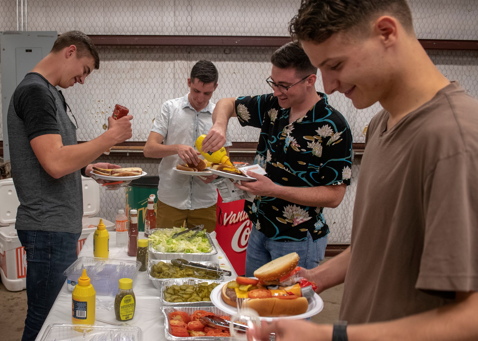 Members of the 97th Training Squadron get condiments from a buffet line during the quarterly Committee of 100 dinner, July 8, 2019, at Altus, Okla. The Committee of 100 is a quarterly event hosted by the community of Altus to welcome newcomers, returning deployers and family members to Altus AFB.