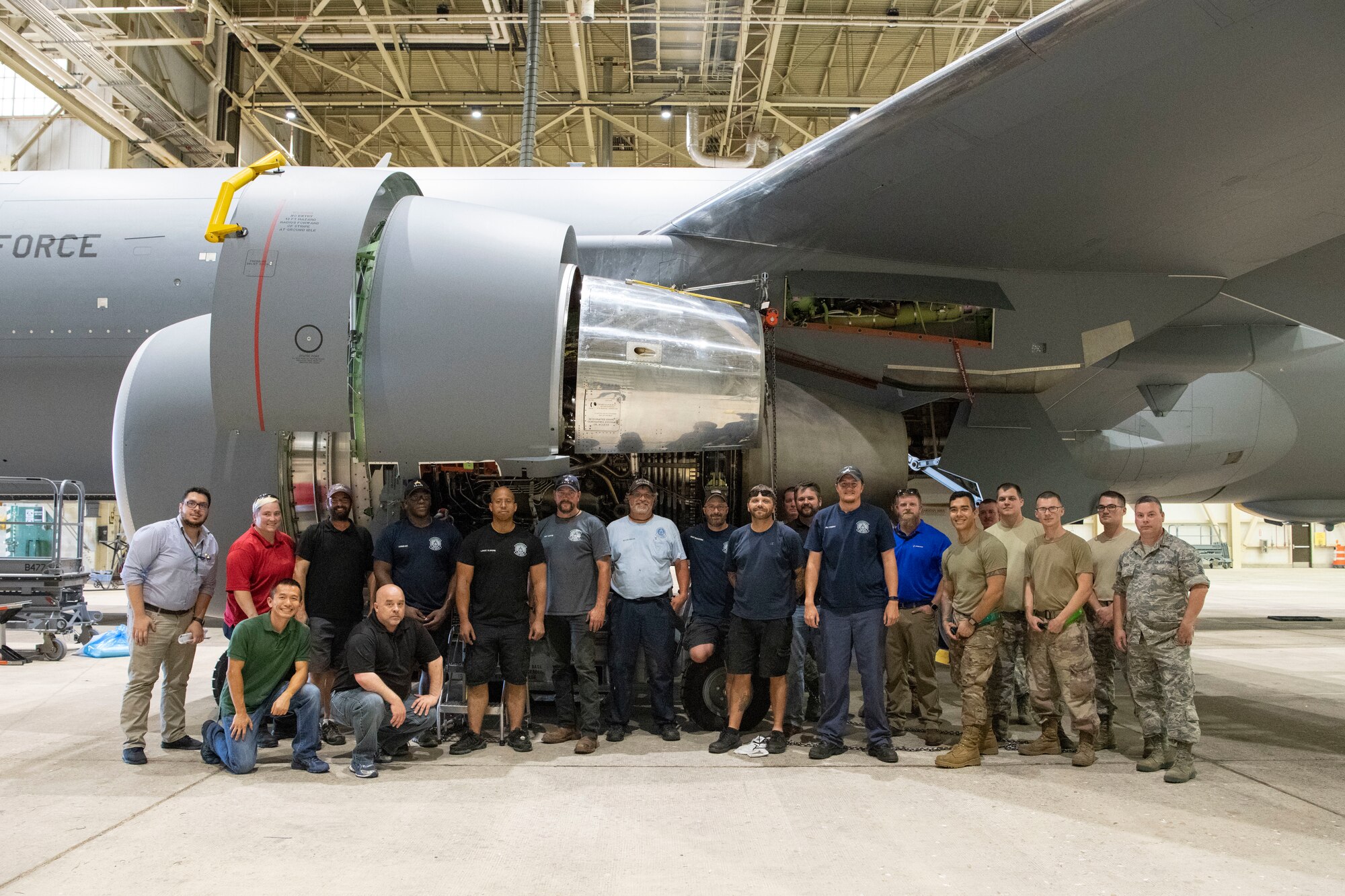 Maintainers pose for a photo after removing the first KC-46A engine.