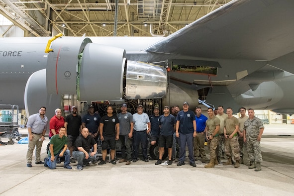 Maintainers pose for a photo after removing the first KC-46A engine.