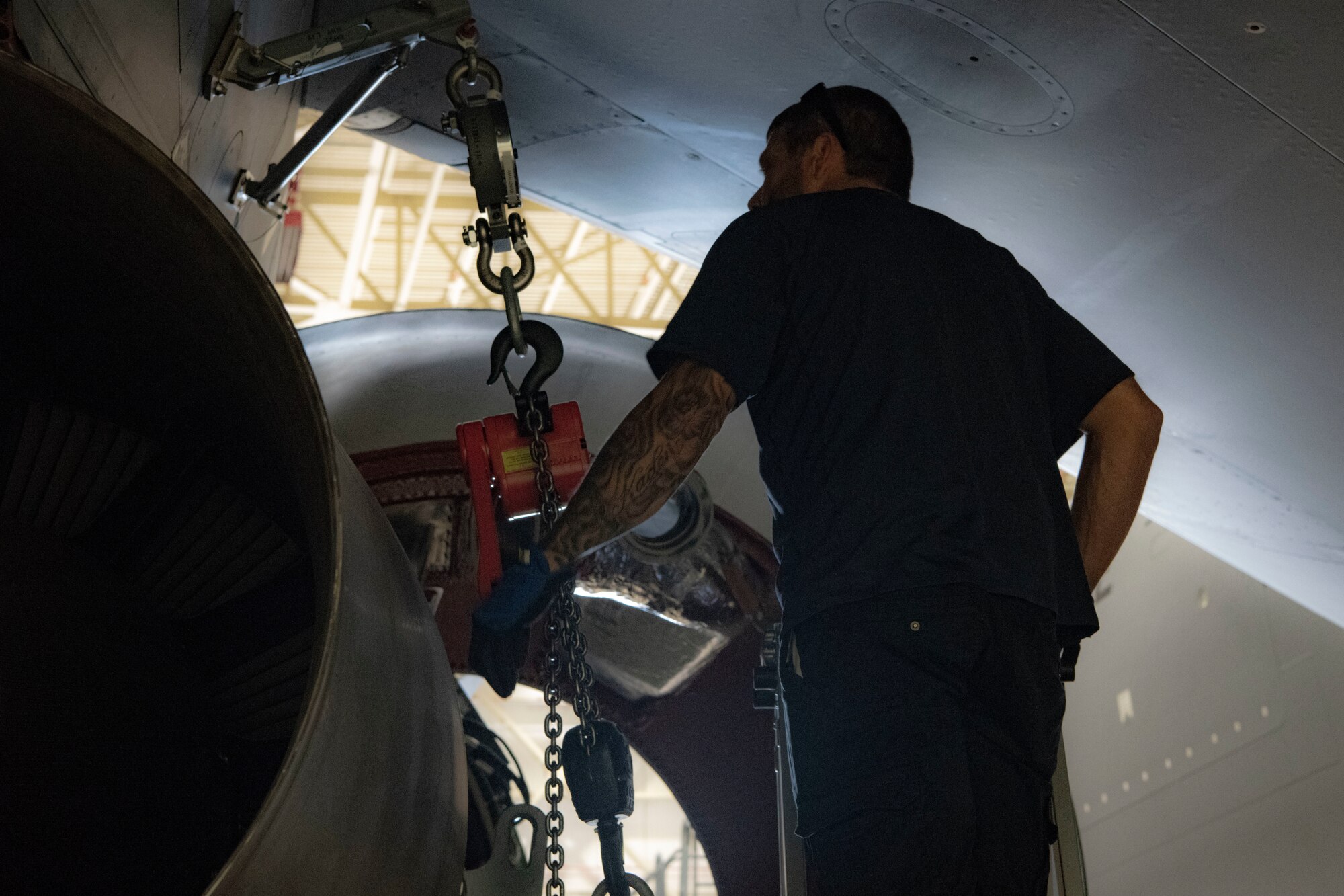 A maintainer helps remove a KC-46A engine.