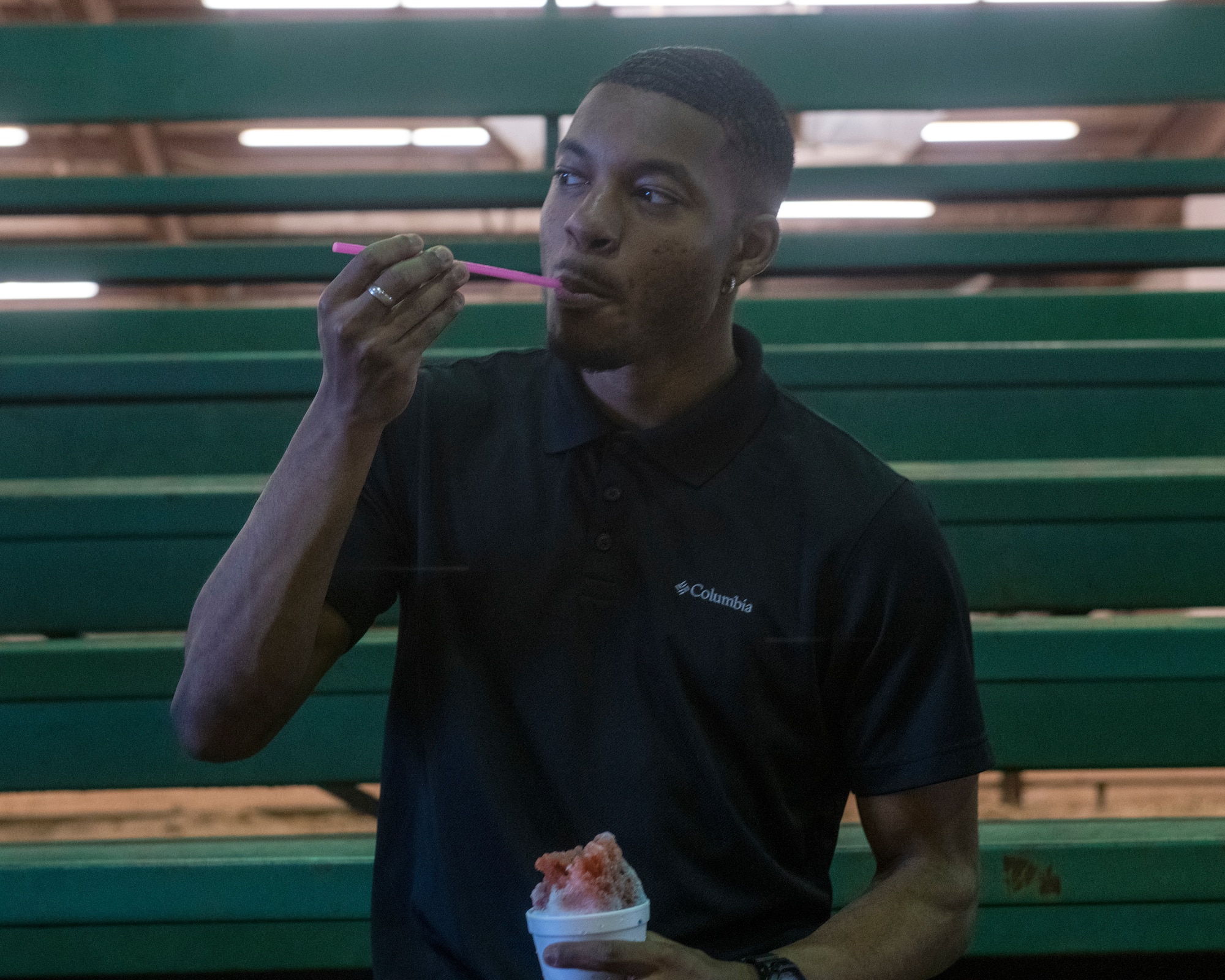 A student from the 97th Training Squadron eats a snow cone during the quarterly Committee of 100 dinner, July 8, 2019, at Altus, Okla. After the dinner and introductions, the members from the 97th Air Mobility Wing were able to ride a mechanical bull and eat snow cones while children jumped in bounce houses as part of a celebration welcoming new members and families to the area.