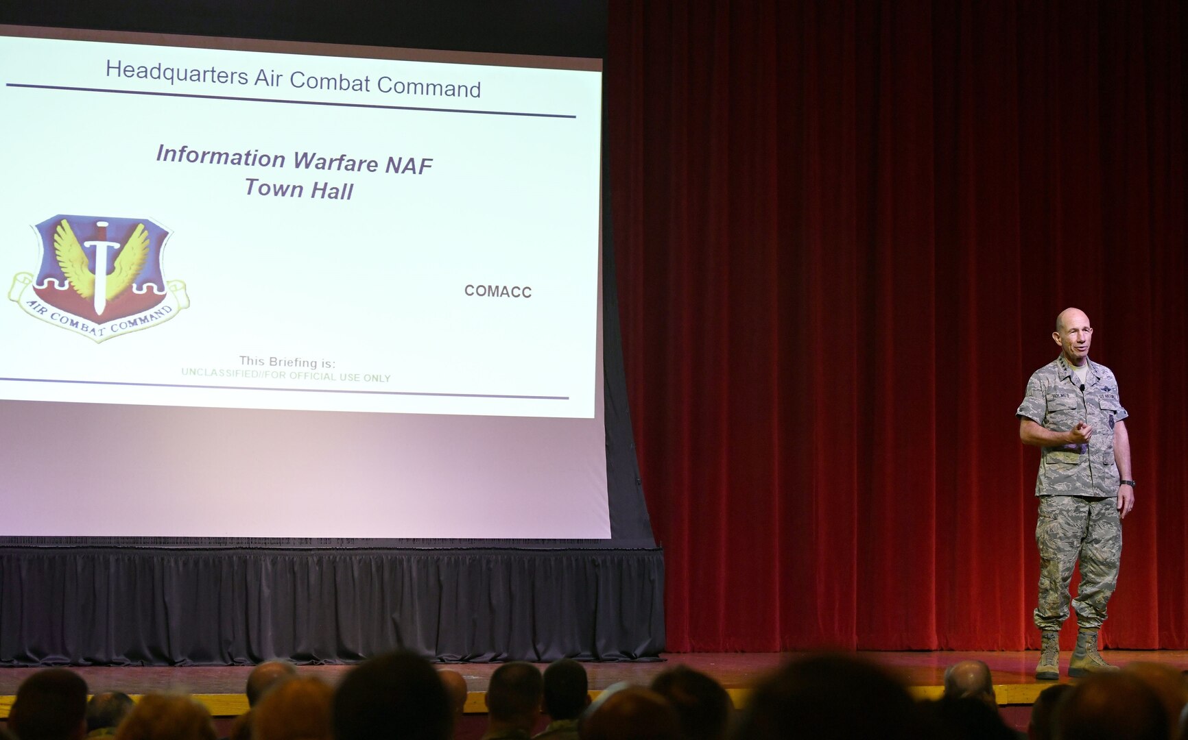 Gen. Mike Holmes, commander of Air Combat Command, greets attendees at a town hall meeting to discuss the future 24th and 25th Air Force merger at Joint Base San Antonio-Lackland July 8. The merged information warfare numbered air force will integrate cyberspace and intelligence, surveillance and reconnaissance to best deliver information warfare capabilities and effects.