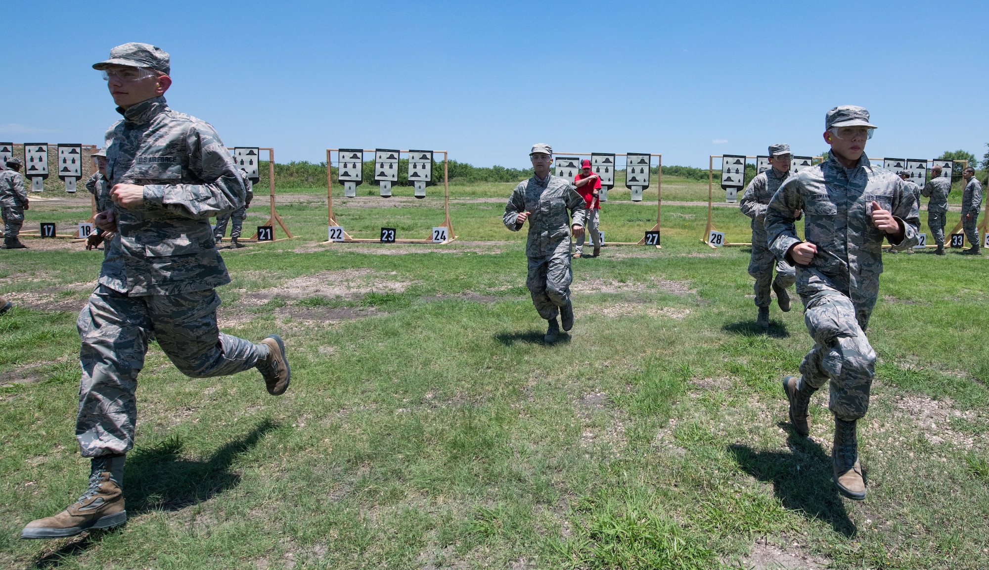 Air Force Basic Military Training trainees run back to their firing position after seeing their targets during a weapons familiarization course June 8 at Joint Base San Antonio-Medina Annex. The firing range allows instructors to train 244 BMT trainees daily, four days a week, qualifying more than 40,000 BMT trainees in the M-4 carbine annually.