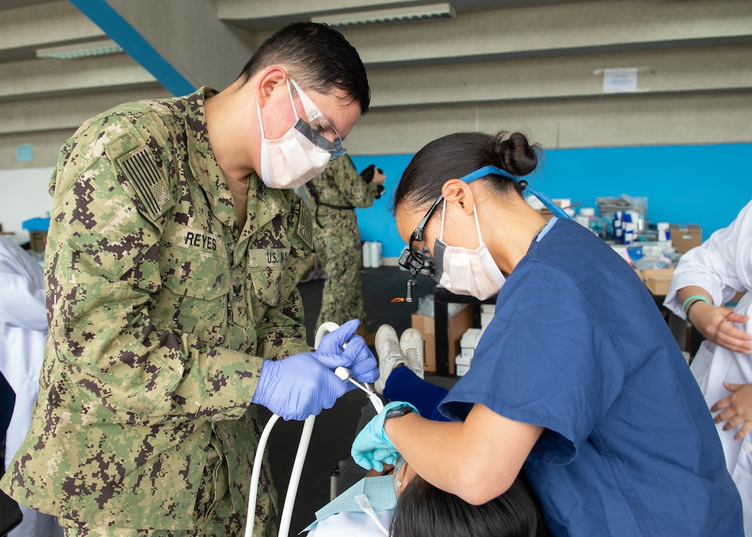 Dentists treat a patient.